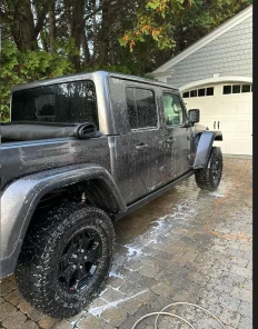 Jeep Gladiator being washed outside a garage