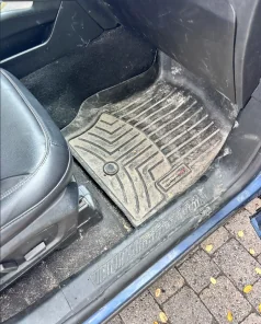 Close-up of a dirt-covered floor mat before cleaning